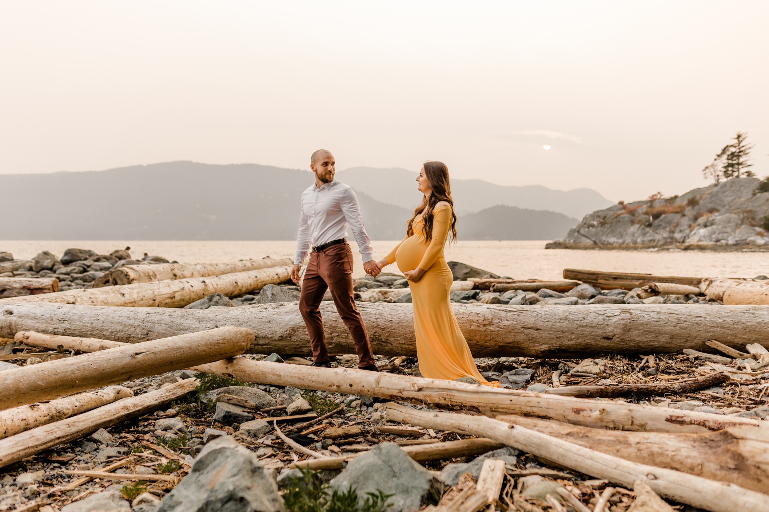 pregnant couple walking along Whytecliff Beach
