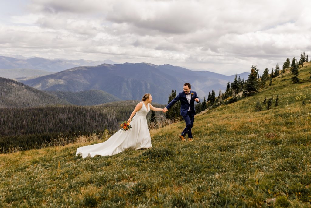 bride and groom running in alpine meadows manning park