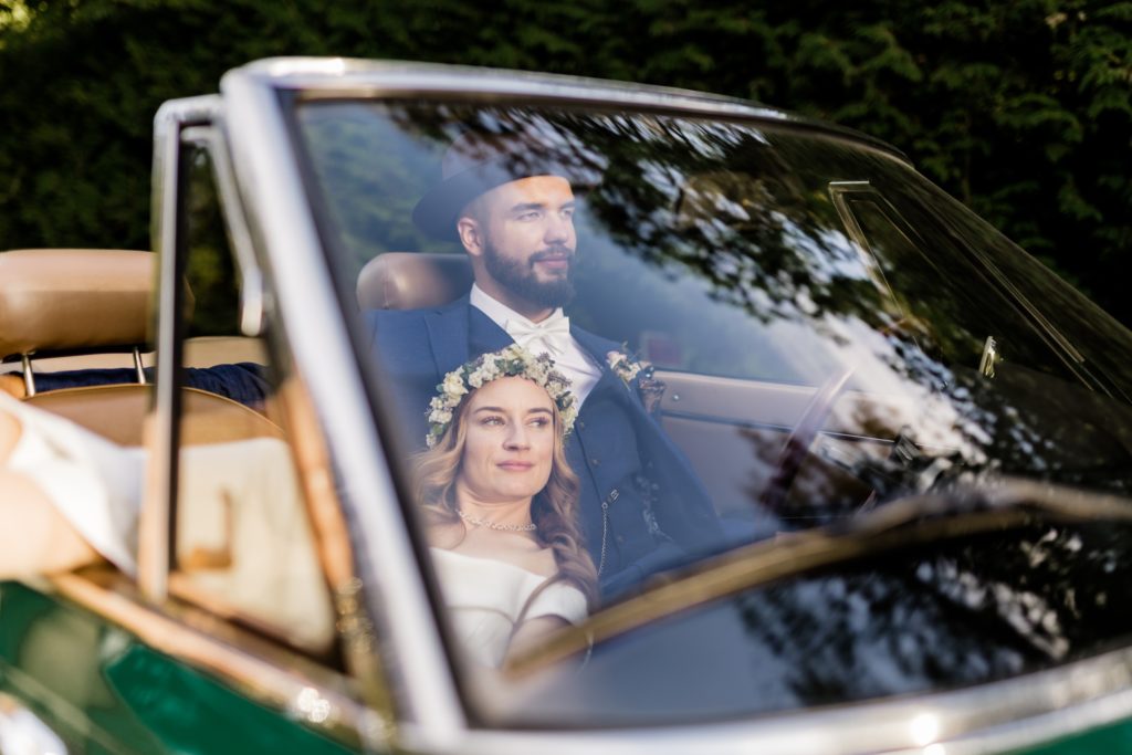bride and groom in the classic car and snuggle with each other