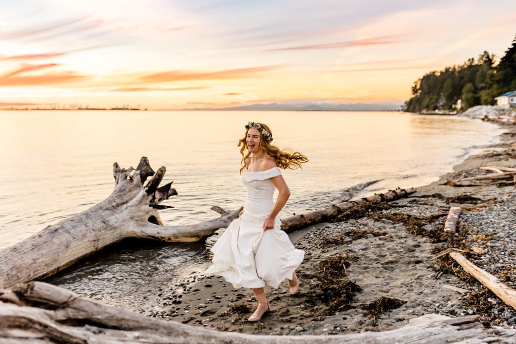 bride runs along the beach during sunset